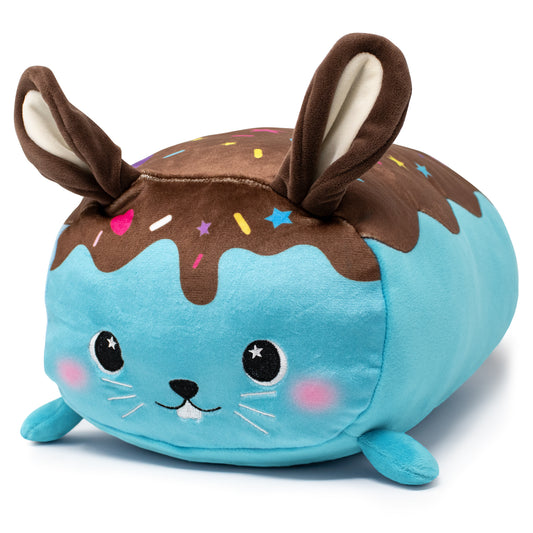 Bitty the Bunny Plushie is a soft, plush toy that looks like a round blue bunny with chocolate frosting-patterned top and colorful sprinkles. It features floppy ears, starry eyes, pink cheeks, and a small smile.