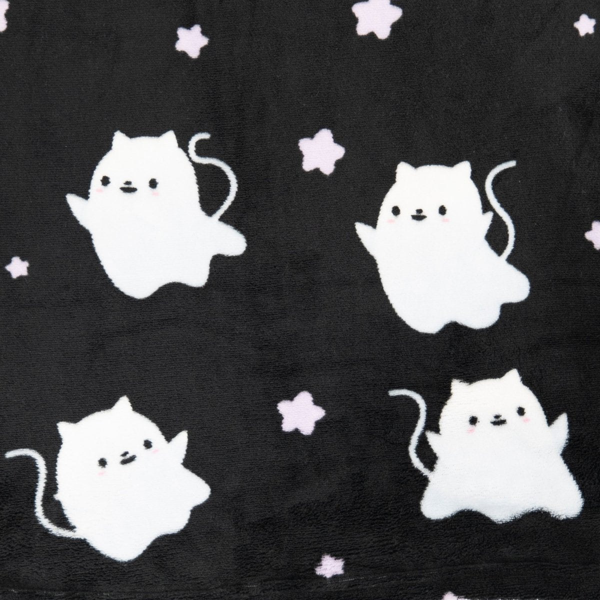 The Fortune the Cat Hooded Blanket is made from black fabric with a repeating pattern of cute white cartoon cat-ghosts with pink cheeks and small pale pink stars.