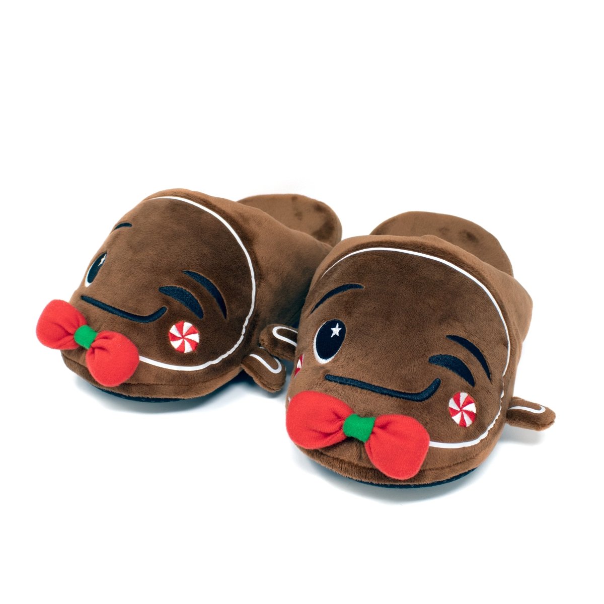 Gingersnaps the Gingerbread Slippers feature a plush brown design with white icing accents, cute faces, red bows, and peppermint details, offering a cozy treat-like feel for your feet.
