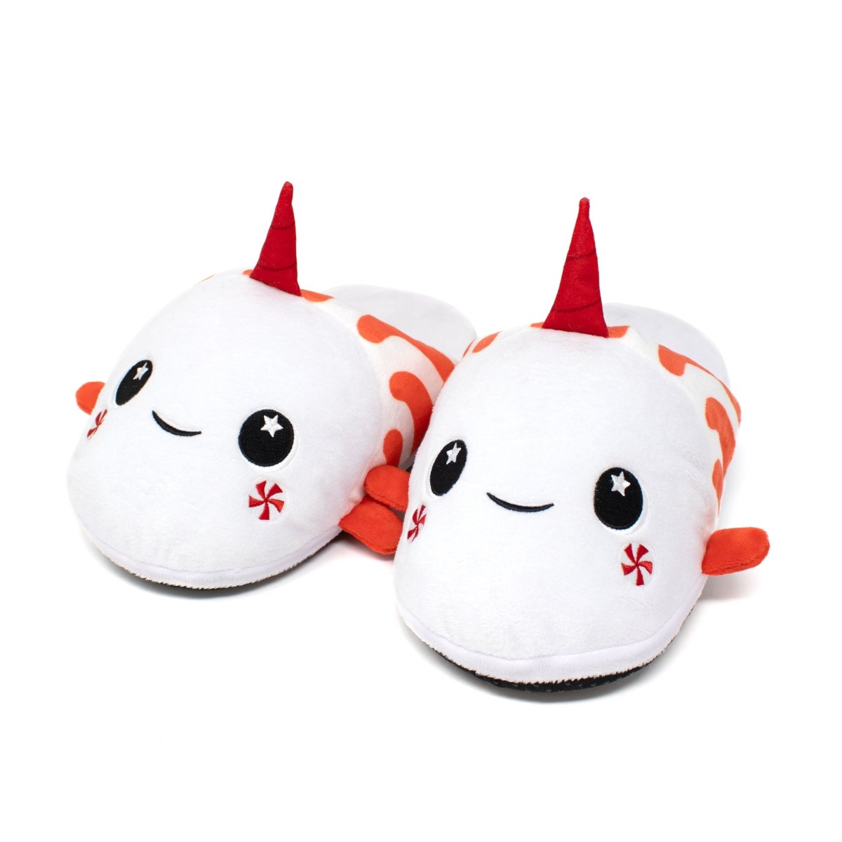 Mintie the Mint Slippers are plush, cozy holiday slippers shaped like whimsical narwhals, featuring red horns, orange accents, smiling faces, and sparkling star eyes—perfect for relaxing nights in.