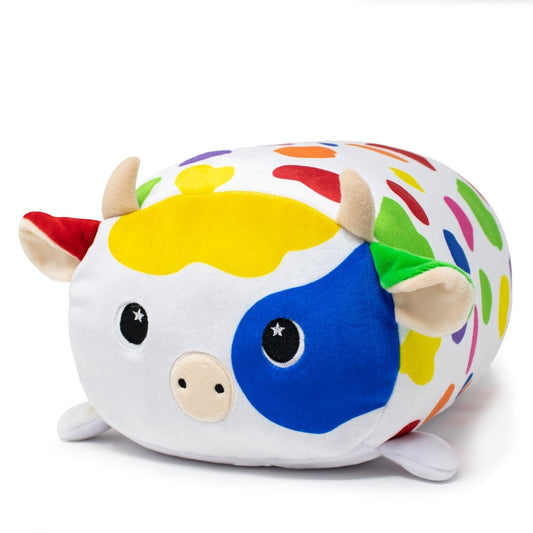 Introducing Clara the Cow Plushie, a cuddly toy with a white body adorned with multicolored spots. Her charm is enhanced by beige horns, a yellow forehead patch, and blue and red patches around her eyes—an ideal addition to any plush collection.