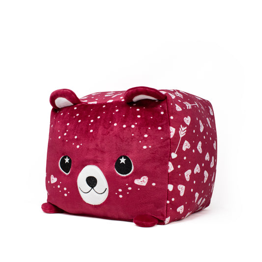 Cupid the Bear Plushie is a cute square cushion that resembles a red bear with small ears and a smiling face, featuring white patterns of hearts, stars, and arrows on its sides. This plush accessory is perfect for adding coziness to any space.