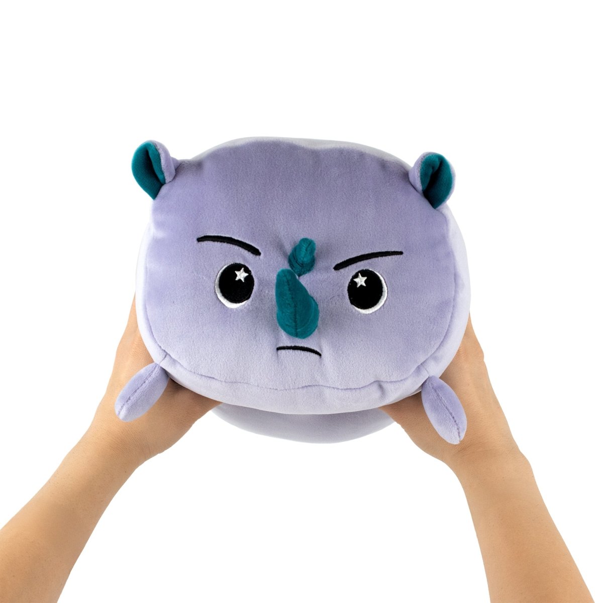Two hands holding Dane the Rhino, a round purple plush toy with teal ears and horn, small limbs, and a serious cartoon expression featuring eyes and furrowed eyebrows.