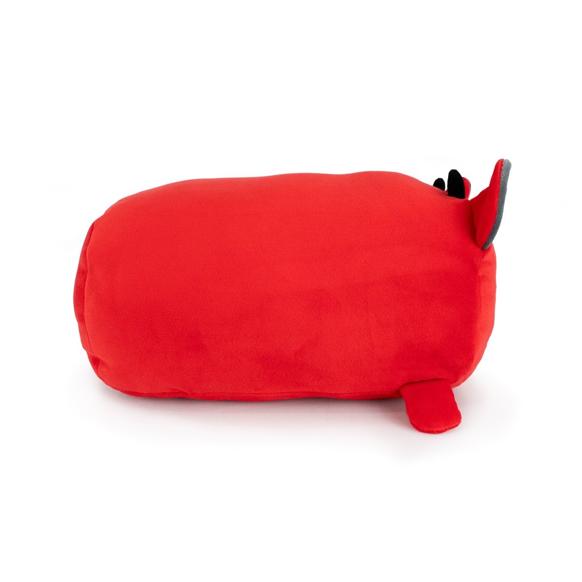 Demian the Demon is a plush toy shaped like a red loaf with small black and gray ears and a red tail, lying on its side against a white backgroundโperfect for snuggling at bedtime.