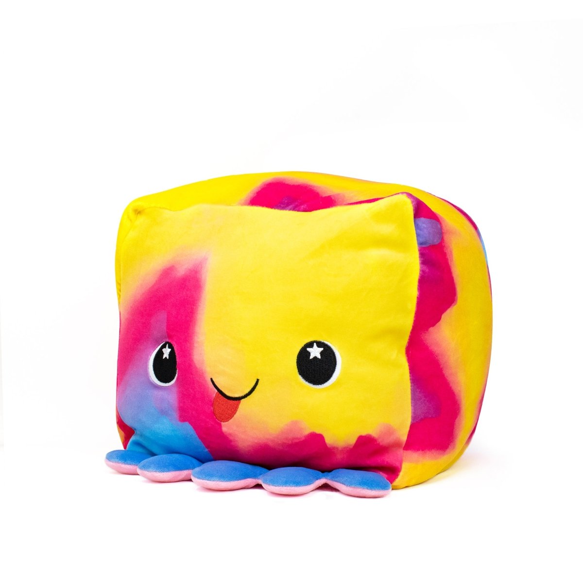 Eve the Octopus Plushie is a rainbow-colored plush cube toy with pink, blue, yellow, and purple hues. It has a smiling face, cartoon-like eyes with star details, and soft blue and pink feet at the bottom for sensory enjoyment.