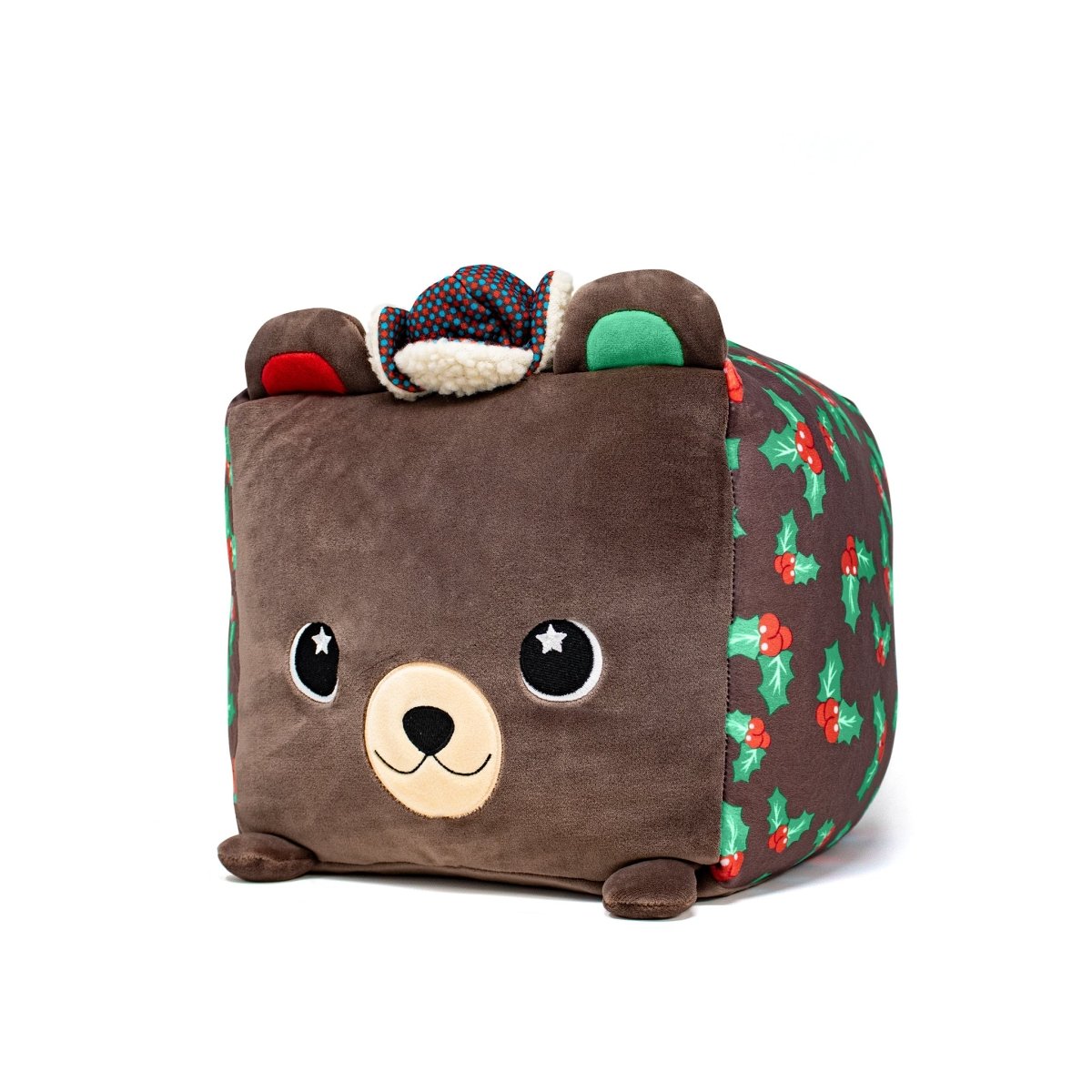 The Holly Plushie is an adorable cube toy featuring a bear face, cowboy hat, colorful holly patterns on its sides, and ears at the top corners, making it a charming addition to any stuffed animal collection.