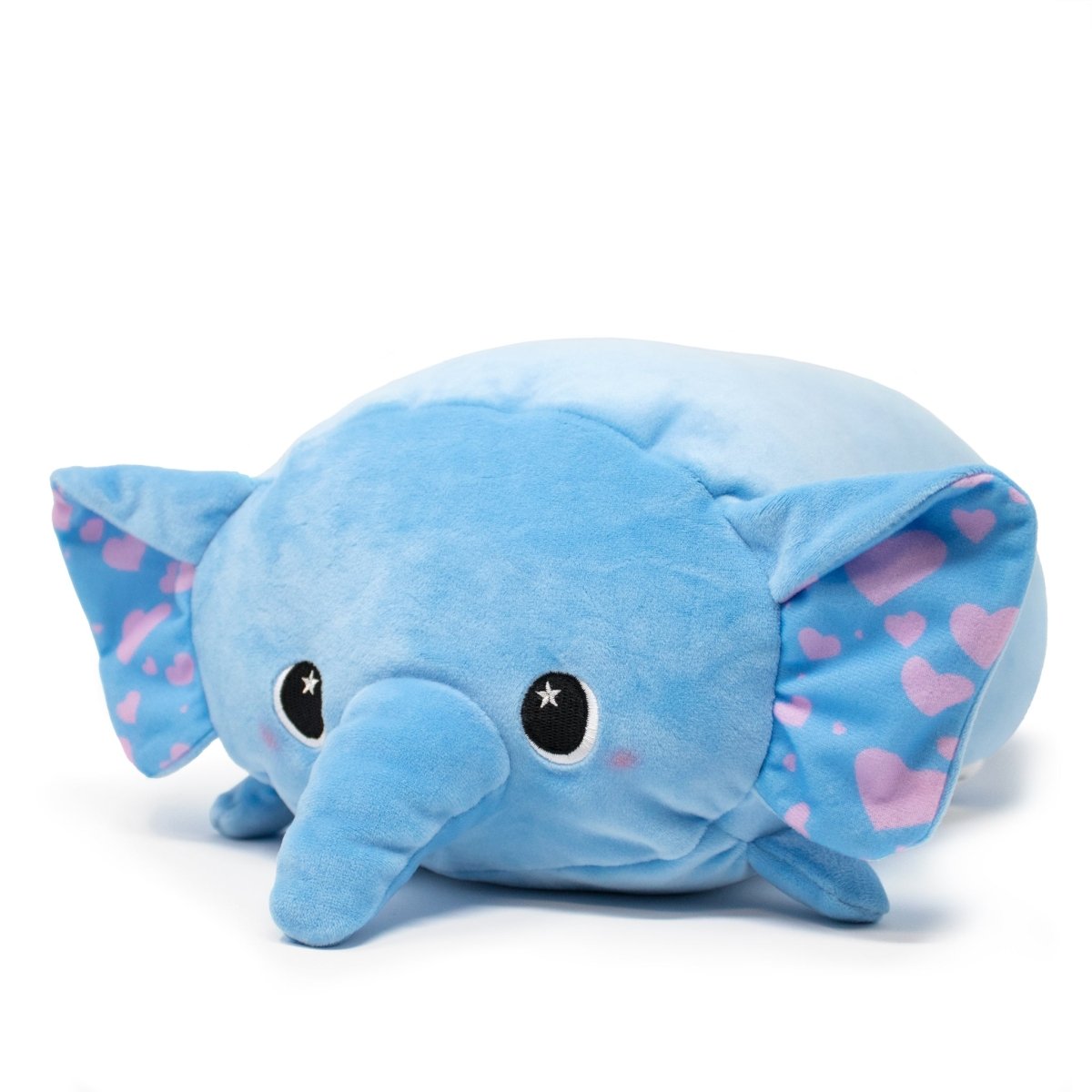 Itsy the Elephant Plushie, soft and squeezable, sits against a white backdrop. It boasts large ears with pink heart patterns, a long trunk, and cartoonish black eyes with white star highlights. For hassle-free maintenance, this adorable blue plushie is conveniently machine washable.