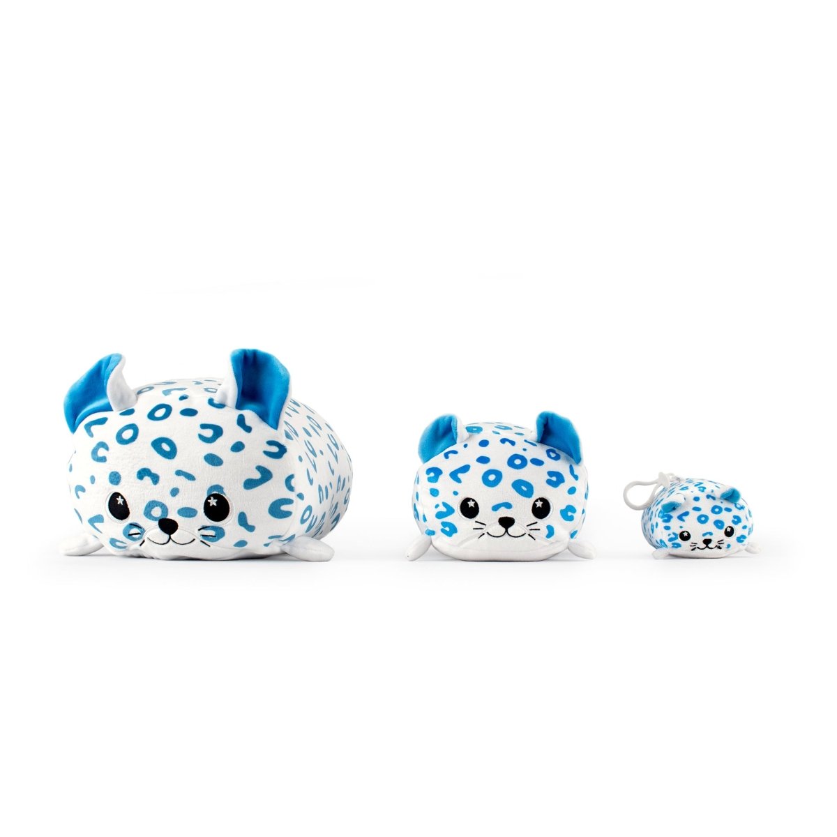 Three "Snowie the Snow Leopard" plushies in various sizes are lined up. Each toy features blue spots, blue ears, and small black eyes on a plain white background.