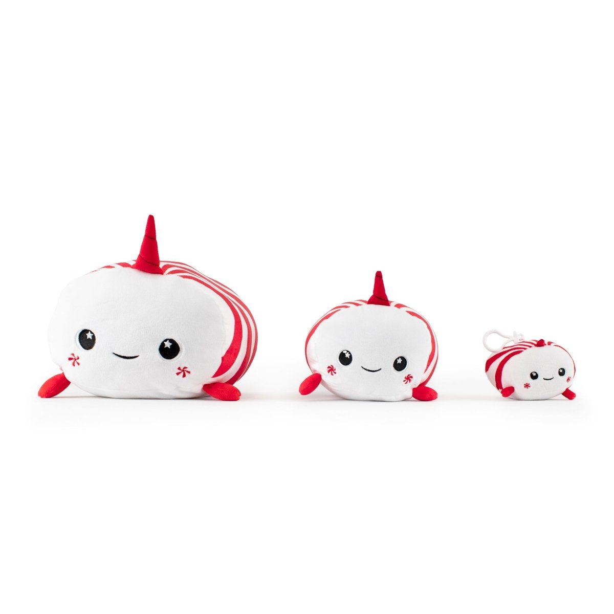 Three Mintie the Narwhal mint plushies, featuring red and white stripes and happy faces, are displayed from largest to smallest. Perfect as Christmas gifts, the smallest one includes a handy keychain.