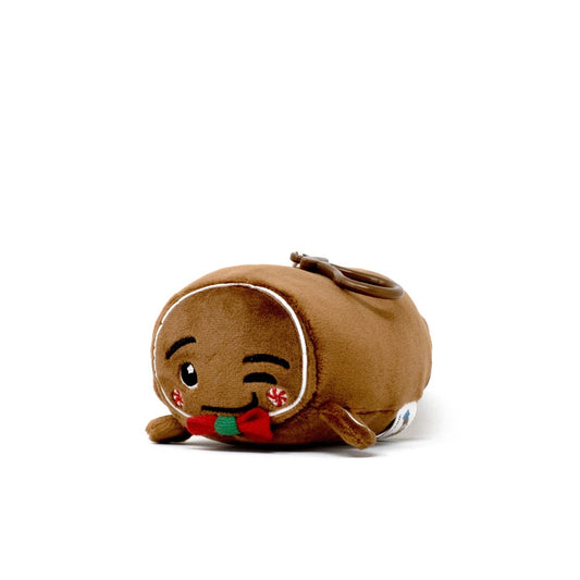 The Gingersnaps Clip-On is a small plush keychain shaped like a brown loaf of bread with a winking face, red bow tie, and peppermint candy cheeks—perfect as a cute holiday plushie or winter accessory.