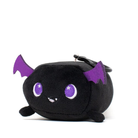 Cassie the Bat Clip-On is a cute black plush bat with purple wings, large purple eyes, and a smiling face, featuring a clip on top.