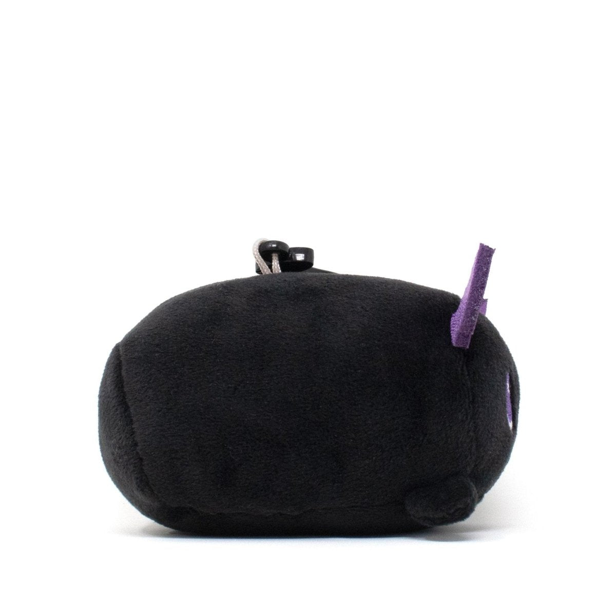 The Cassie the Bat Clip-On is a small, round black plush toy with purple accents against a white background. Its soft feel and minimalist design make it irresistibly cute, even without visible facial features.