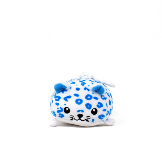 Snowie the Snow Leopard Clip-On is a round, plush keychain toy with blue spots, small blue ears, black eyes, and a little smile—perfect as a cute holiday accessory.