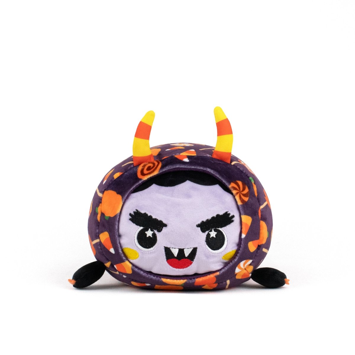 Meet the Fang Spooky Slumber Plushie: an ultra-soft, round stuffed toy with a purple face, fangs, angry eyes, candy corn horns on a patterned hood, small black arms and feet. It’s machine washable for easy care.