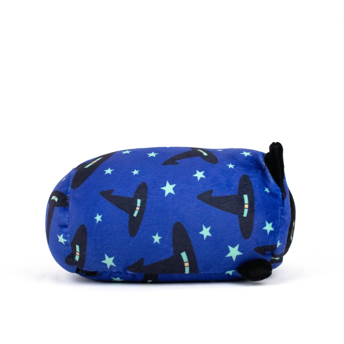 The Fortune Spooky Slumber Plushie, a loaf-shaped plush toy made from ultra-soft material and covered in blue fabric adorned with black witch hats and green stars, lies on its side against a white background.
