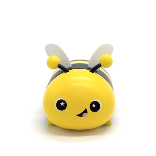A cute, cartoonish yellow-and-black Vee the Bee Vinyl Collectible Figurine with big starry eyes, a smiling mouth, and two wings on its back is shown against a plain white background.