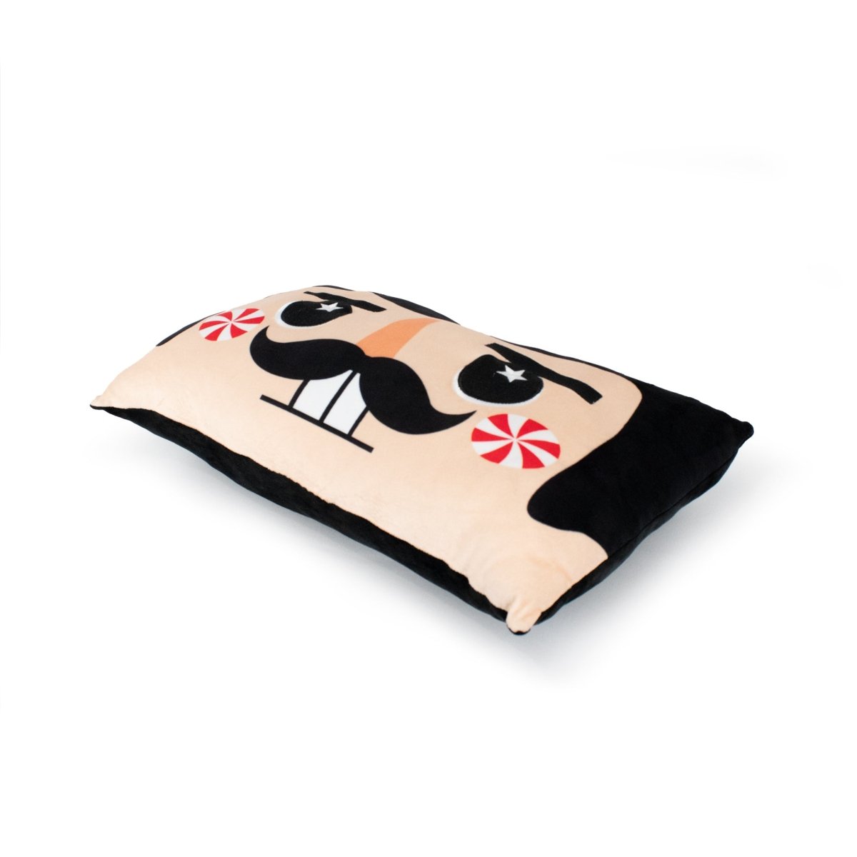 Stuart the Nutcracker Pillow features a cartoon face with a black mustache, star-shaped eyes, red peppermint cheeks, and a wide smile on a white background—perfect for holiday décor.