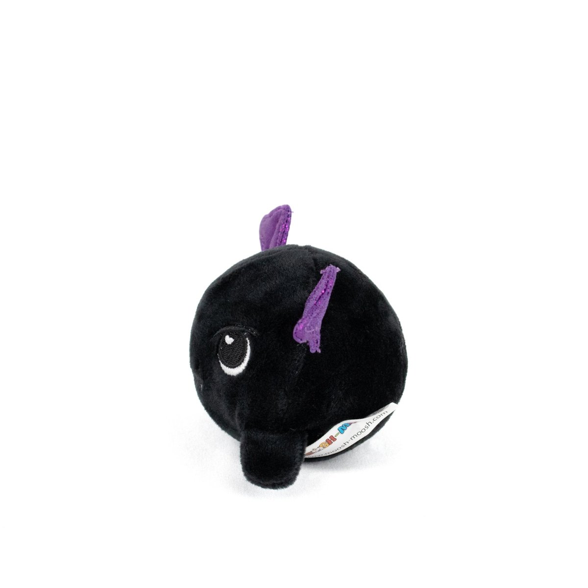 The Kai Spooky Plushy Skwishy is a small, round black plush toy with an embroidered eye, purple fabric ears or fins, and a bottom tag, shown on a white background.