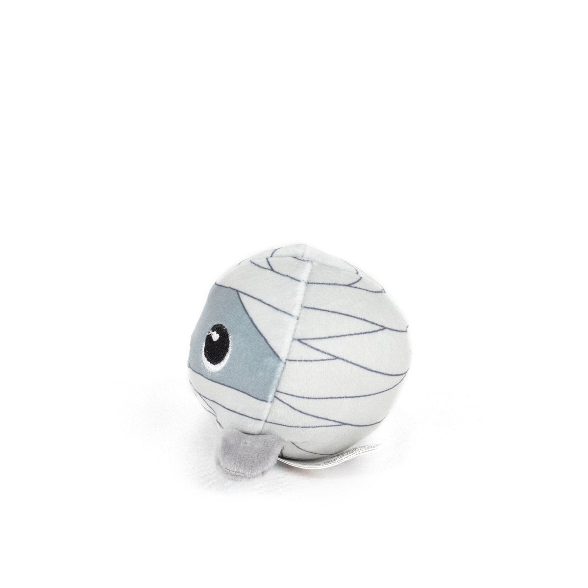 The Nile Spooky Plushy Skwishy is a round plush toy styled as a mummy, featuring white fabric with grey bandage-like lines and one large eye. It's shown against a plain white background.