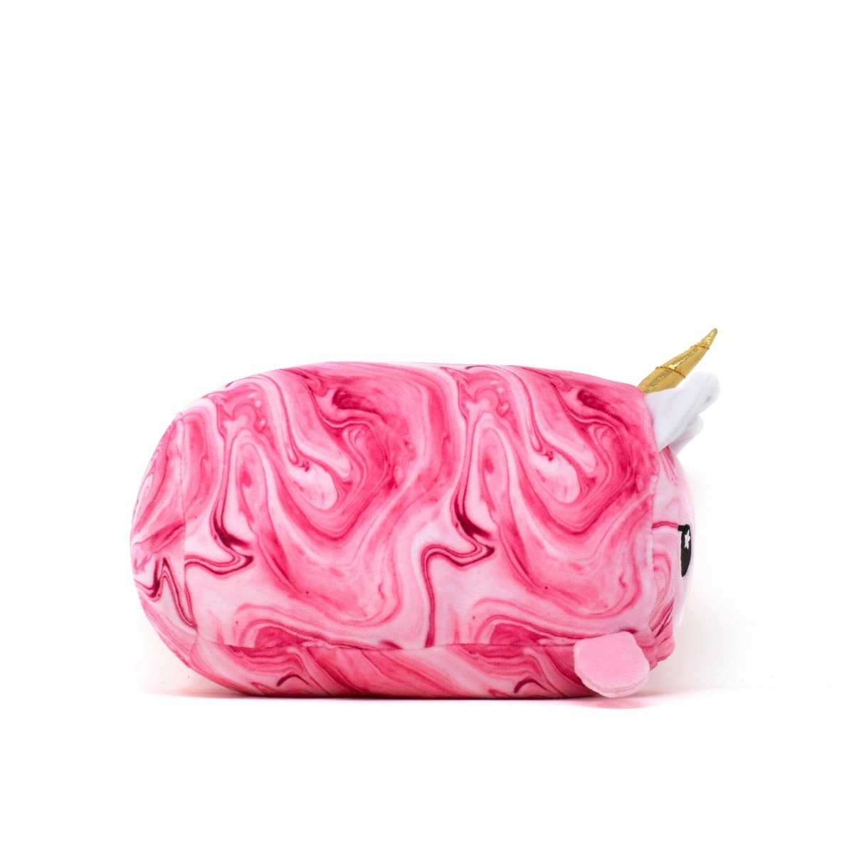 The Lucy Slumber Plushie is a whimsical cat-shaped plush with a golden unicorn horn, featuring a pink and white swirled pattern. Its soft form lies on its side against a white background, highlighting the small pink ear that peeks out.