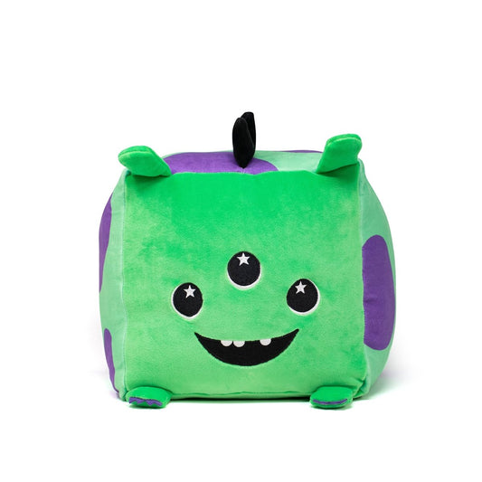 Sibyl the Alien Plushie: A square green stuffed toy featuring a smiling face with three eyes, small pointed ears, and a black tuft on top. The plushie has purple spots, is made of machine washable fabric, and resembles a cute alien against a plain white background.