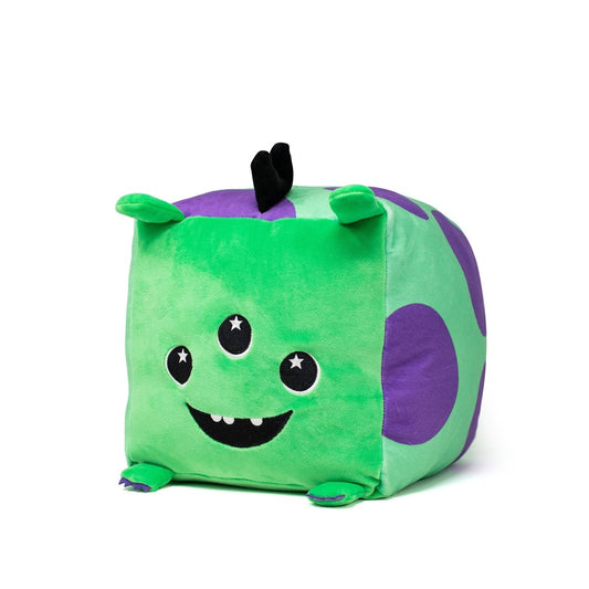 Sibyl the Alien Plushie is a cube-shaped, machine-washable toy with a bright green body, purple spots, three eyes, a smiling mouth with two teeth, and small black horns. Cartoonishly monstrous yet adorably huggable!.