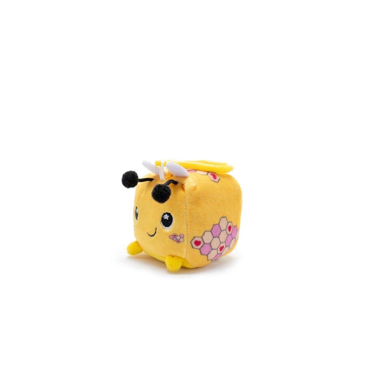 Hex the Bee Square Plush Clip-On from Moosh-Moosh Series 1 is a cheerful, cube-shaped toy resembling a bee. It features a smiling face, black antennae, white wings, and pink honeycomb patterns on its yellow body set against a plain white background.