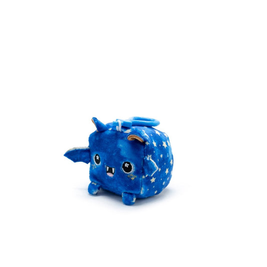 Meet Orion the Bat Square Plush Clip-On from Moosh-Moosh Series 1—a cube-shaped, blue plush toy with star patterns. It has tiny wings, a horn, a round top tail, and an adorable face with large eyes and a small mouth. Its clip-on feature adds to its irresistible charm.