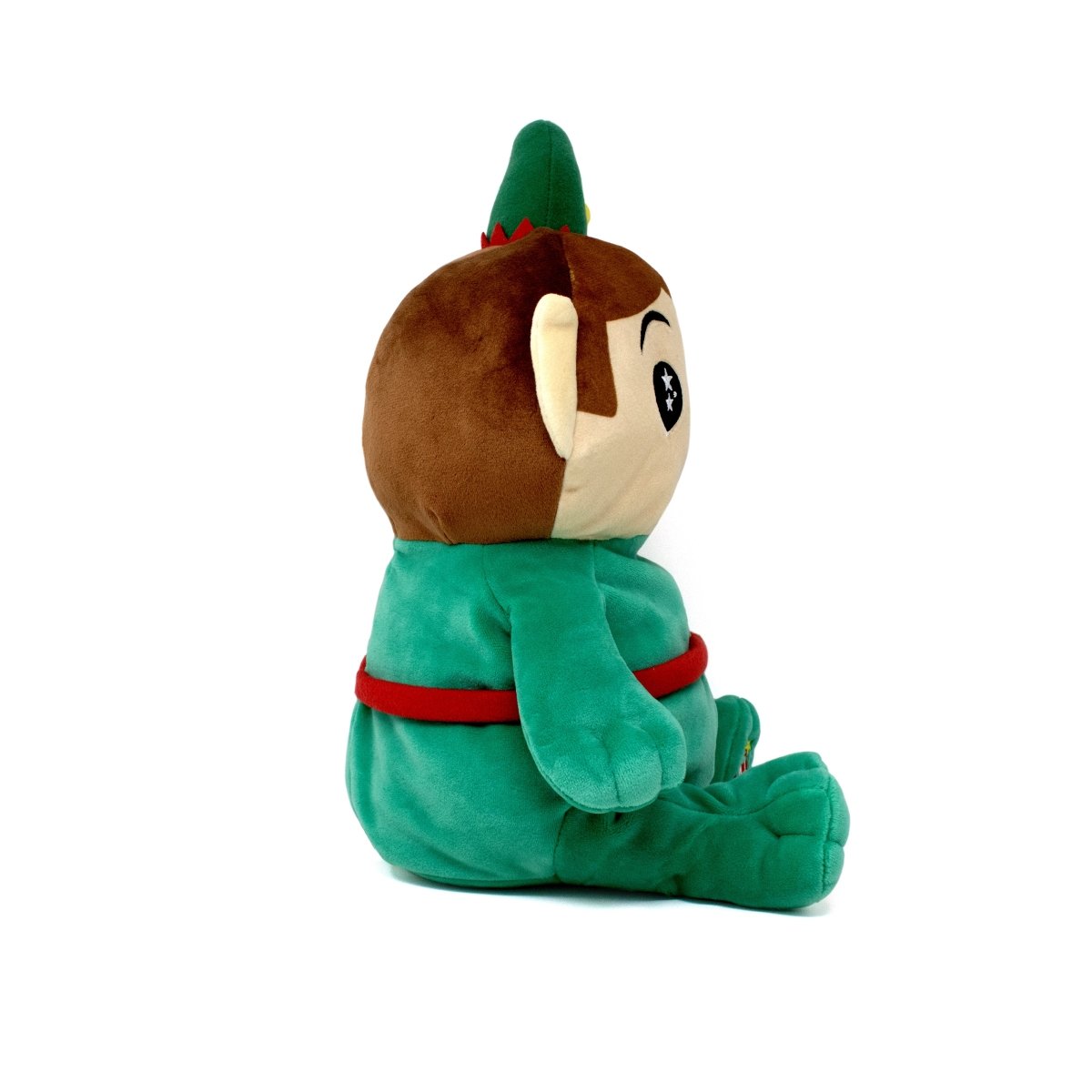 A side view of Jingle the Elf Starlight Buddy, a holiday plush in green with a red belt and hat, sitting upright on a white background. The toy features brown hair, a round face, and star-shaped eyes.