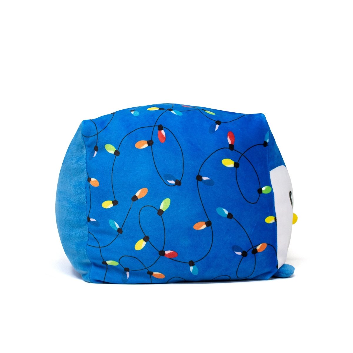 A blue, cube-shaped Tanzy Plushie holiday toy decorated with colorful Christmas lights and a small, partially visible white face on one side.