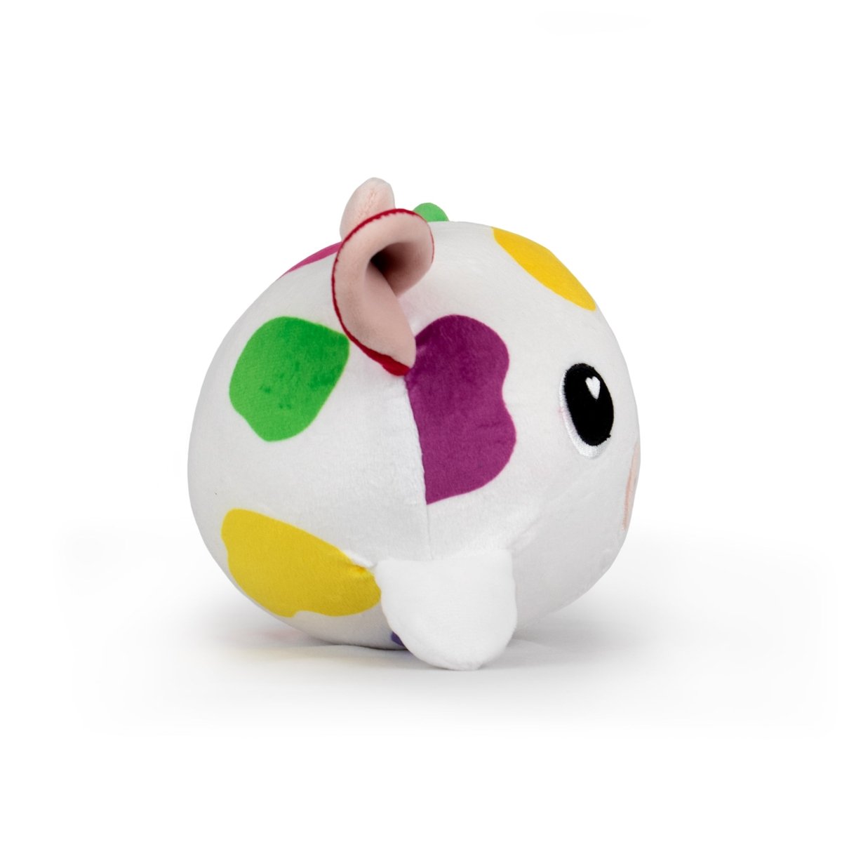 The Jumbo Plushy Skwishy Clara is a white, round plush toy featuring colorful spots in green, yellow, and purple. It has tiny ears, a small nose, and a black eye, resembling a cute cartoonish animal like a cow.