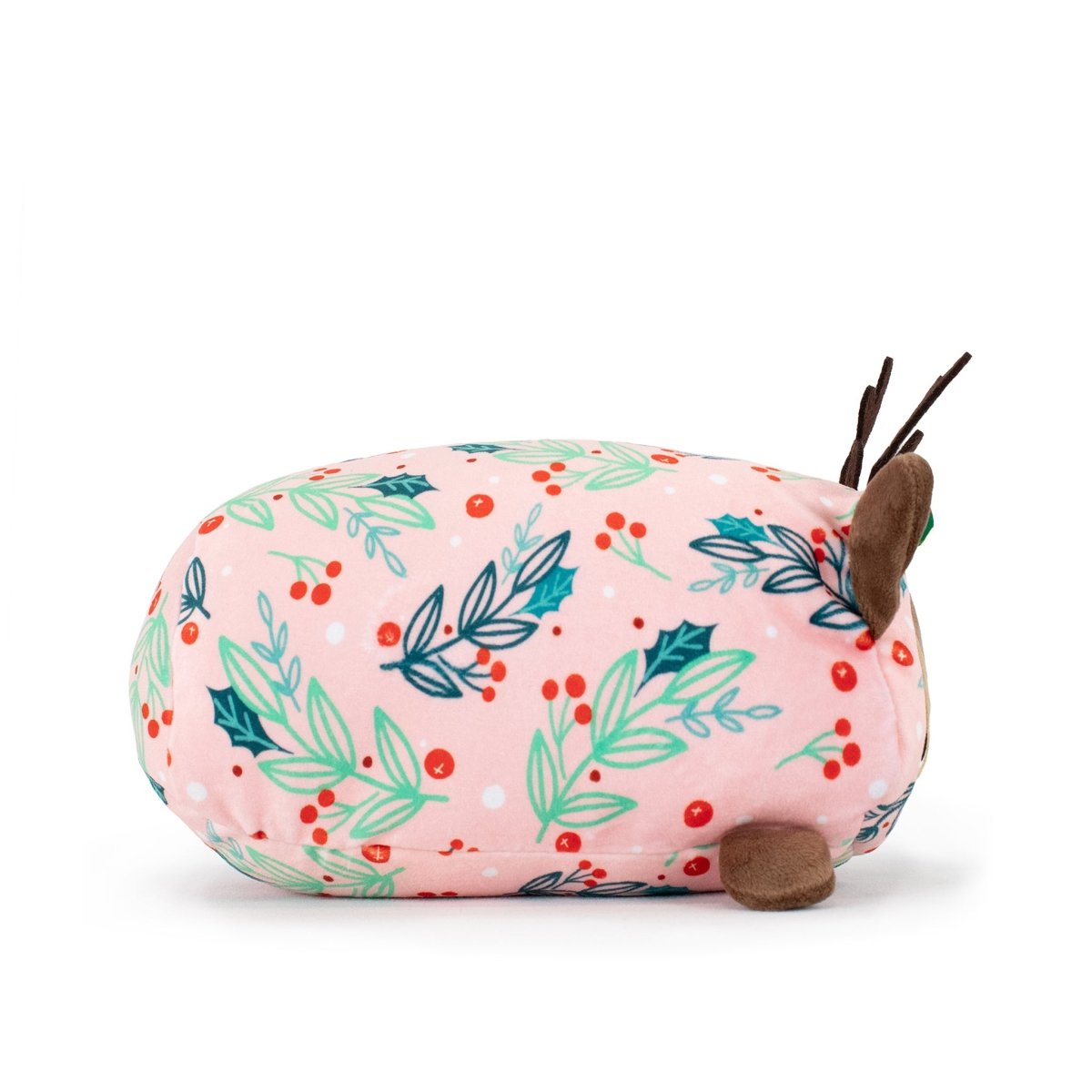 Mitzy the Reindeer Slumber is a soft, oval-shaped holiday plush with a pink background, green leaves, red berries, brown ears and antlers, and a light green embroidered nose—perfect as a festive Christmas gift.
