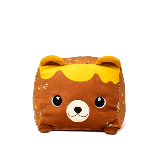 Meet Mel Bee the Bear Plushie, a cute brown bear cube featuring big eyes and a small smile. It has yellow honeycomb accents, small ears and feet, and is adorned with tiny bee and flower patterns.