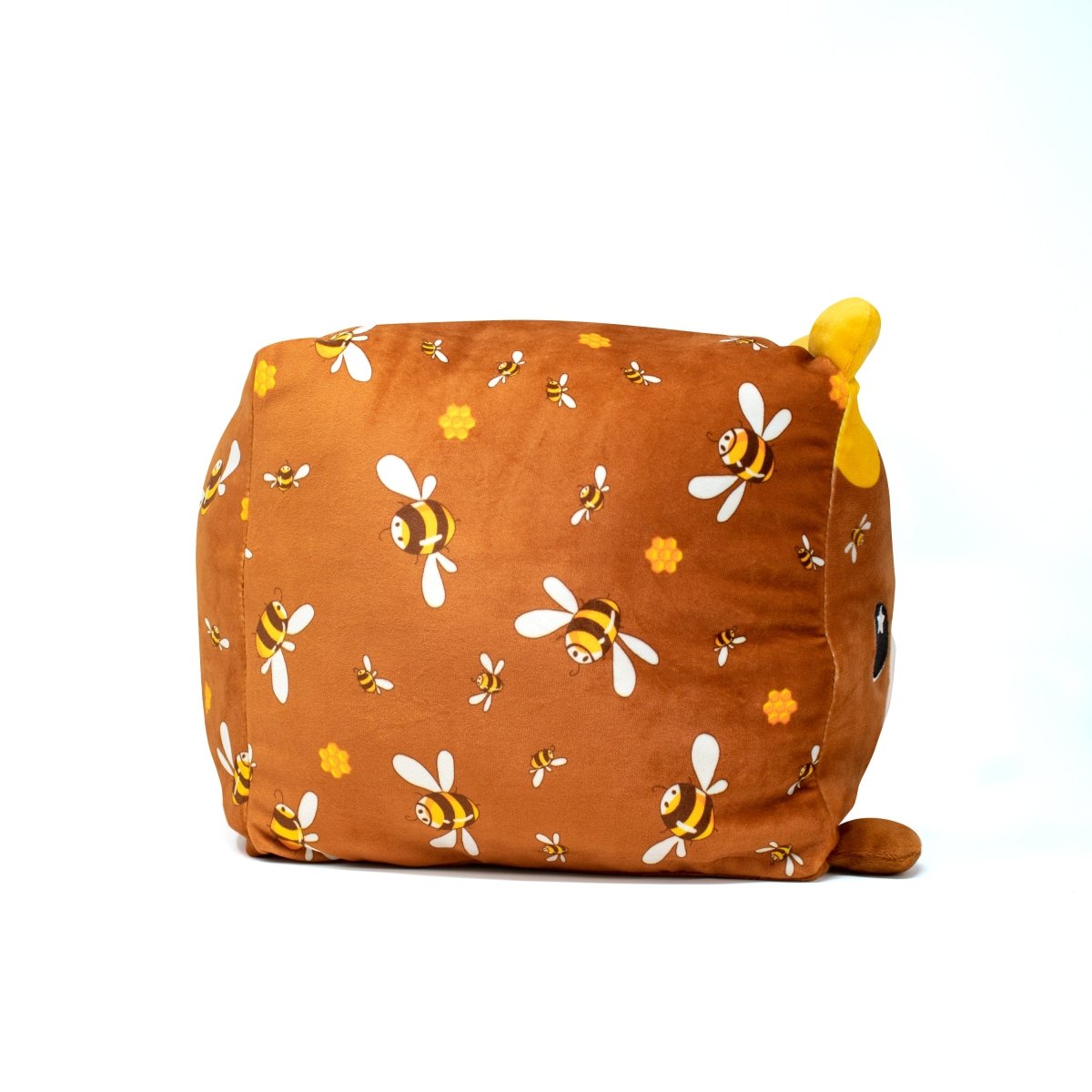 Meet Mel Bee the Bear Plushie, a charming square plush adorned with a bee pattern on brown. Tiny bees dance across its surface, complemented by a small yellow protrusion. This adorable toy, set against a plain white background, invites cuddles and smiles.