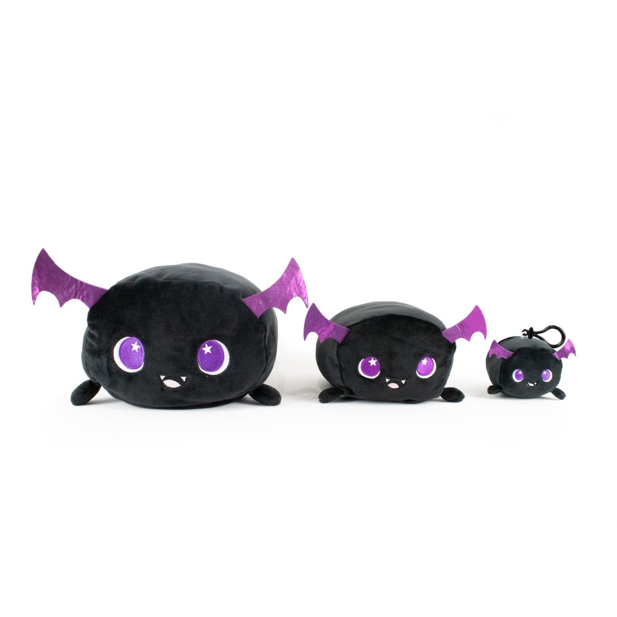 Cassie the Bat Plushies come in three sizes from largest to smallest, each an adorable black plush with purple ears and wings. They feature a cute, smiling face with big, starry purple eyes.