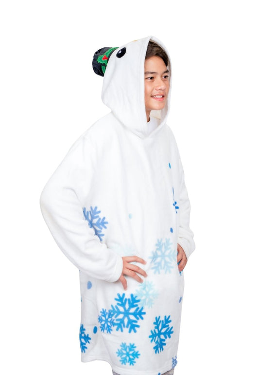 A person wearing the Jack the Snowman Hooded Blanket, featuring a cozy white design with blue snowflake patterns and a penguin headpiece, smiles and looks to the side like an adorable plushie on a plain white background.