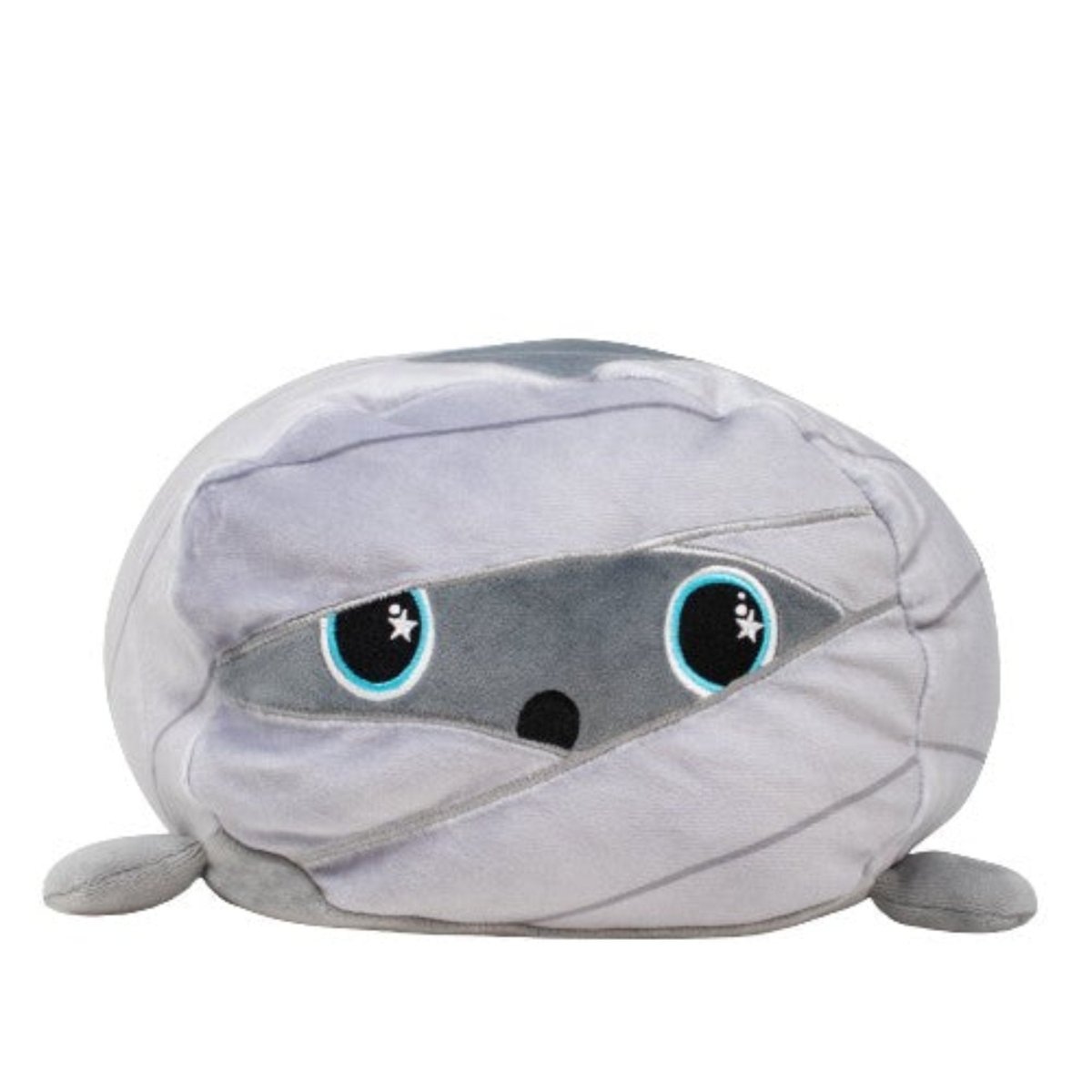 Nile the Mummy Plushie is a cute, gray, round stuffed animal with big blue eyes and small outstretched arms. Its plush fabric is wrapped like mummy bandages, giving it a whimsical look.