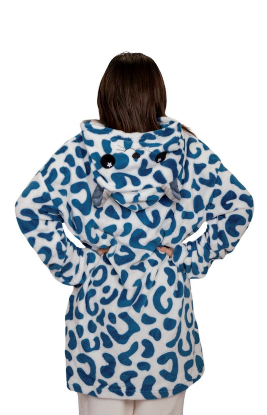Someone stands with their back to the camera, wearing the Snowie the Leopard Hooded Blanket, featuring a blue and white design with playful animal ears and a face on the hood.