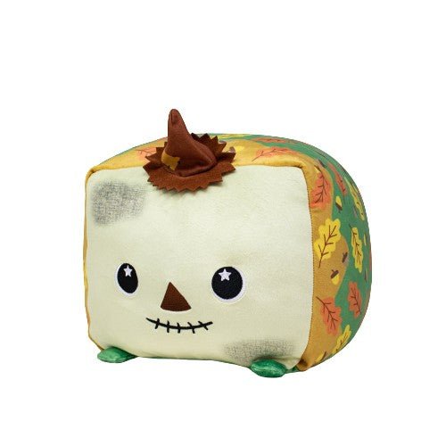 Tatters the Scarecrow is a plush, cube-shaped scarecrow with a smiling face, green feet, a brown patch and hat, and sides decorated with colorful autumn leaves—a perfect cuddly toy for fall.