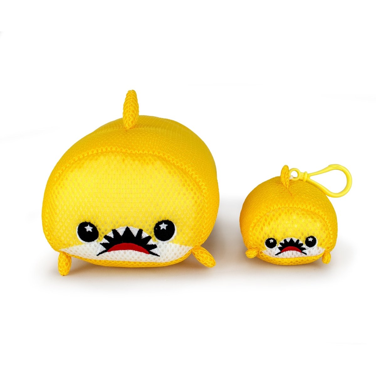 The Aqua Moosh-Moosh Dash set features two yellow plush toy sharks with cartoon faces—one large, one small—both with big eyes and toothy grins. The smaller shark comes with a handy yellow clip for easy attachment.