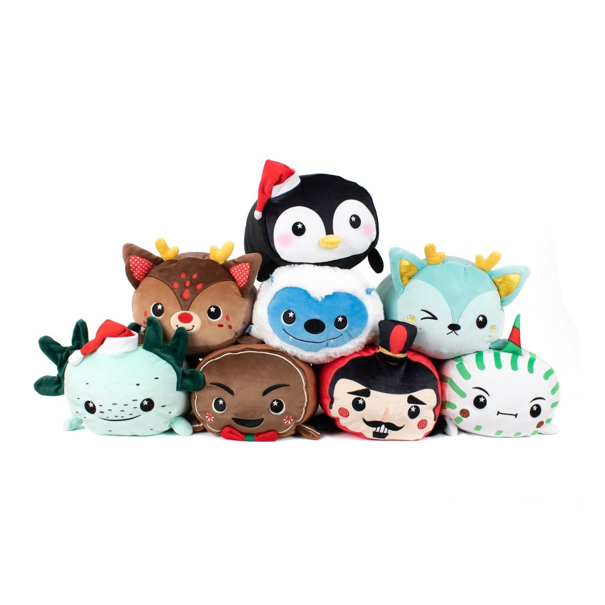 A group of eight plush toys, including a penguin, reindeer, yeti, gingerbread man, nutcracker, and other festive characters, arranged in a pyramid against a white background.
