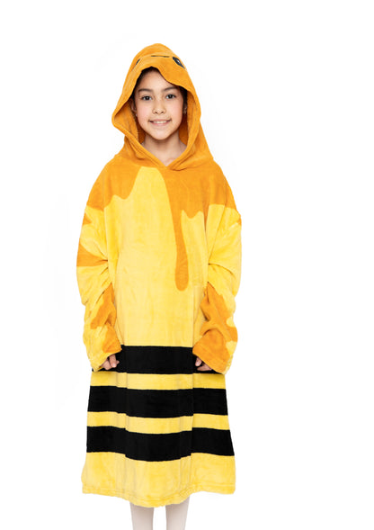 A child smiles while wearing the Hooded Blanket - Vee the Bee, featuring yellow and black stripes with a honey drip design, resembling a bee costume, against a white background.