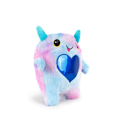 The Cow Bestie Monstah is a machine washable plush toy with pastel blue and pink fur, blue horns, yellow eyes, a smiling face, and a shiny blue heart on its chest, standing upright against a white background.