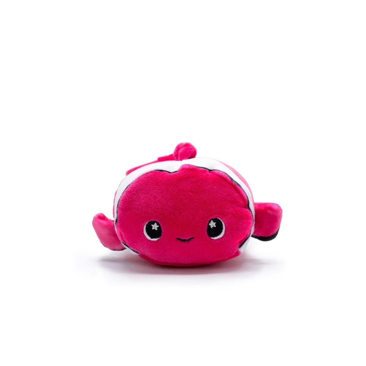 Skipper the Clownfish Plush Clip-On from Moosh-Moosh Series 5 is a small pink plush with big black eyes, a smile, and white stripes. It features two side fins and a top fin in vibrant pink, ideal as a clip-on plushie against any white backdrop.