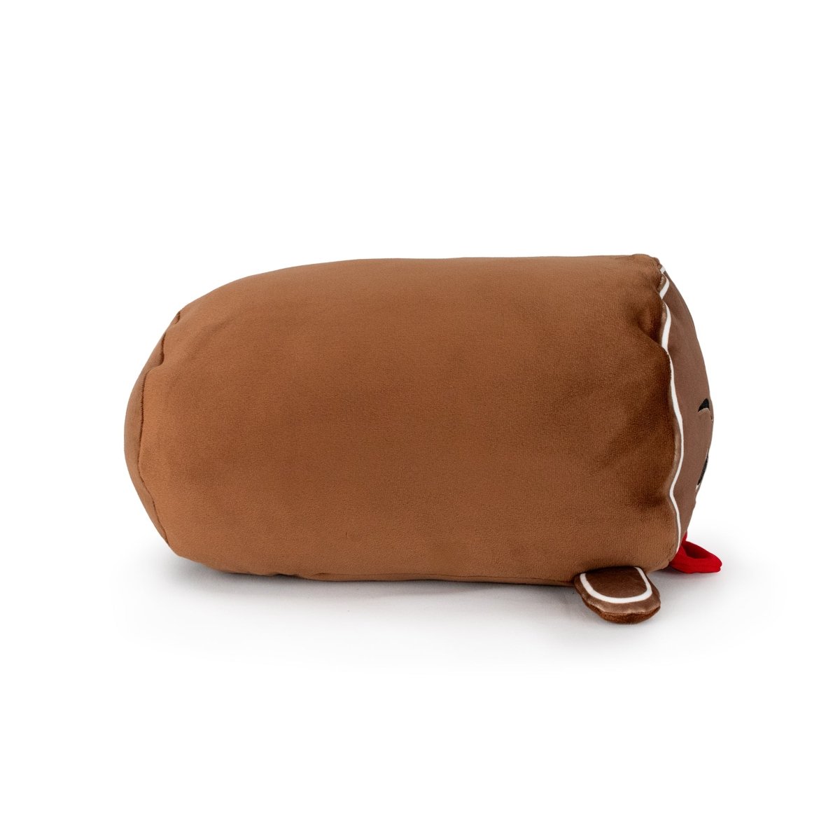 Clovis the Gingerbread Man is a soft, brown, cylindrical plush toy with white icing details, a red felt tongue, and an embroidered smile. Machine washable, he resembles a classic gingerbread cookie and lies on his side.