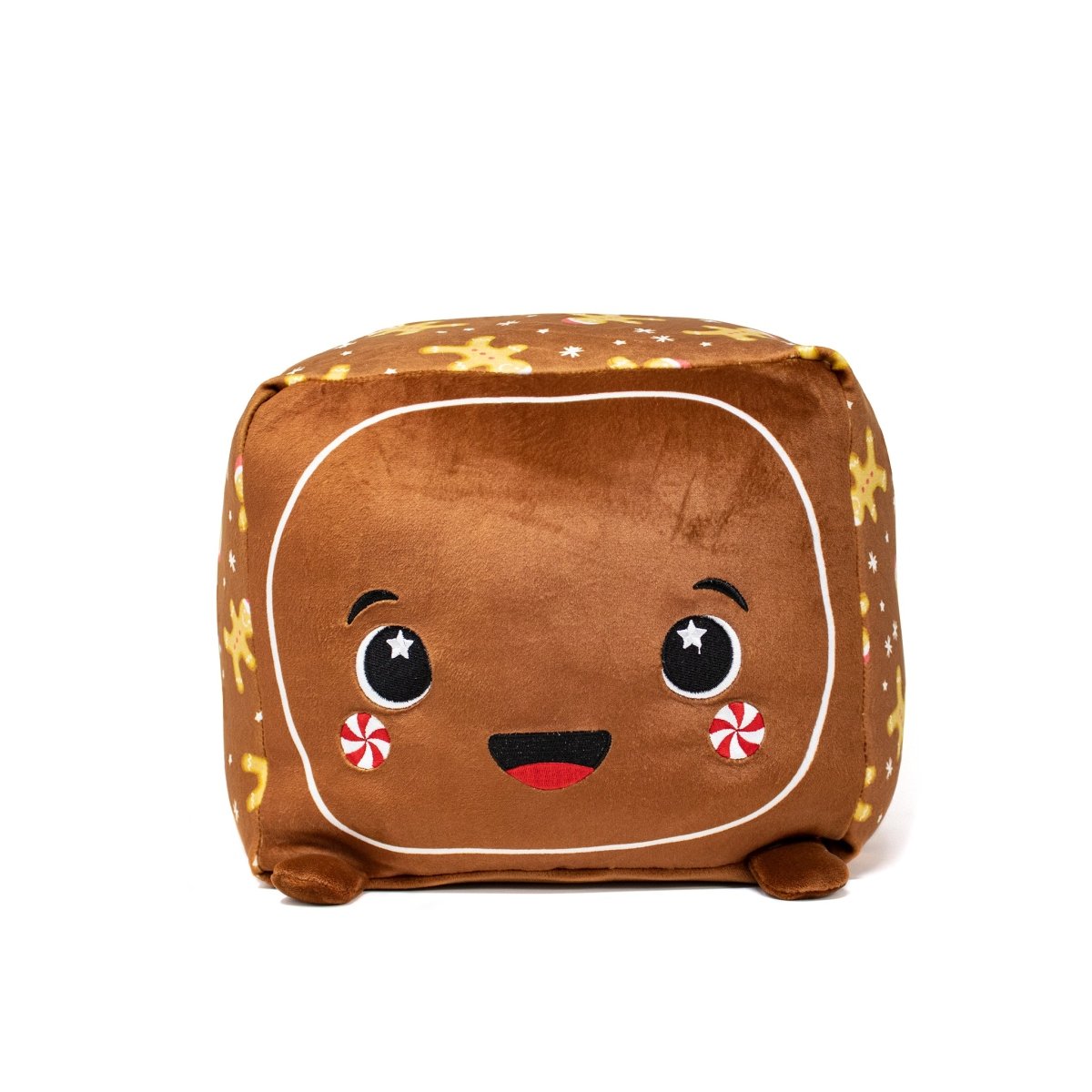 The Crumbles Plushie is a cute square gingerbread character with a smiling face, large eyes, and red candy cheeks. Its brown body features white dots and gingerbread men patterns, making it the perfect addition to any cozy plush collection.