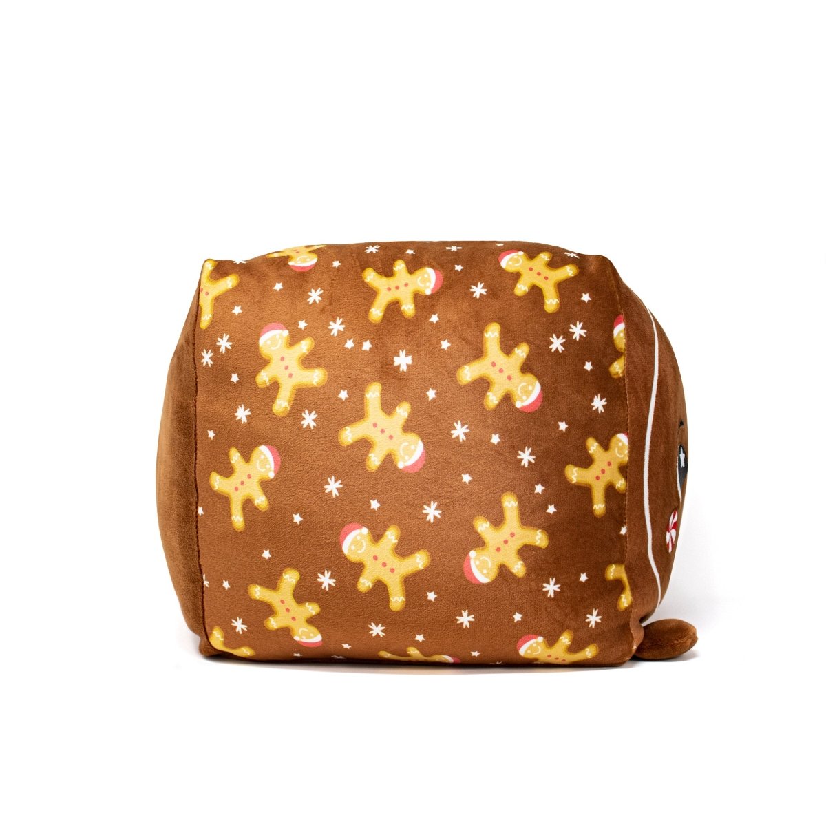 The Crumbles Plushie is an adorable, soft cube featuring a brown surface adorned with gingerbread men and small white stars. One side displays its charming festive design.