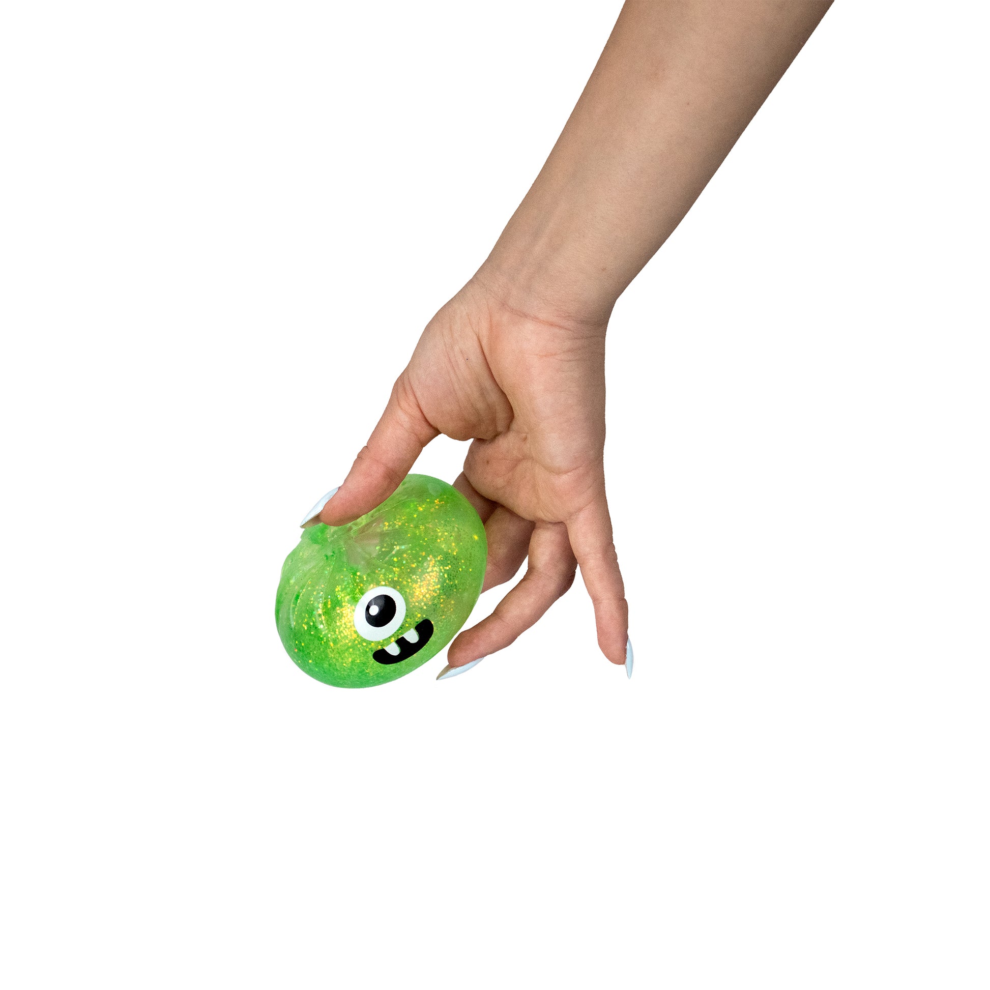 A hand holding Bubblegum’s Favorite Toy - Spooky Mystery Dumpling, a green, glittery, blob-shaped toy with a cartoon face featuring one large eye and a wide smile, against a white background.