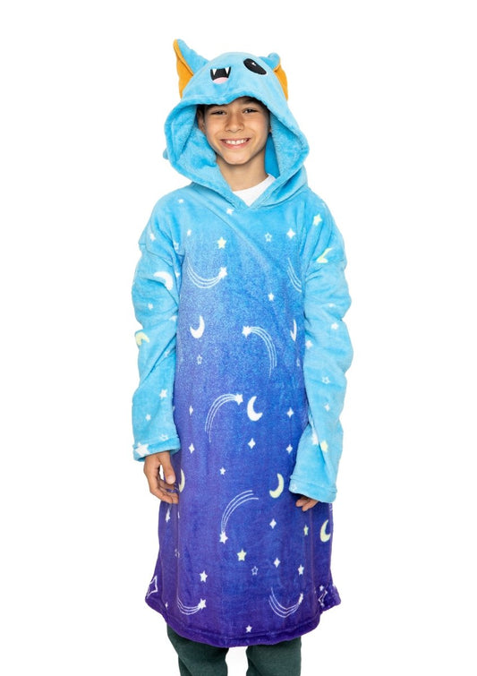 A smiling child wears the Hiso the Bat Hooded Blanket, featuring bat ears and celestial designs on the hood, standing against a white background.