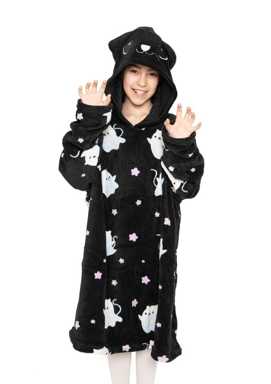 A smiling child poses with hands raised like paws, wearing the Fortune the Cat Hooded Blanket— a black fleece hooded blanket with cat ears, cat face, and cartoon cats and stars. Perfect for cozy Halloween fun!.